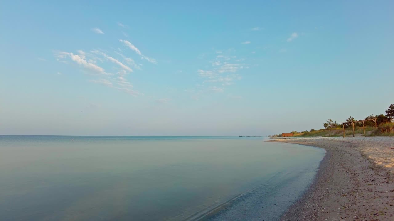 清晨的海岸线，平静的海面和反射的云视频下载