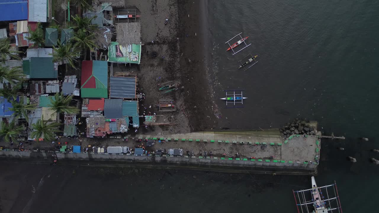 沿着绵延的白色沙滩，渔场旁边的鱼市。无人机空中视频下载