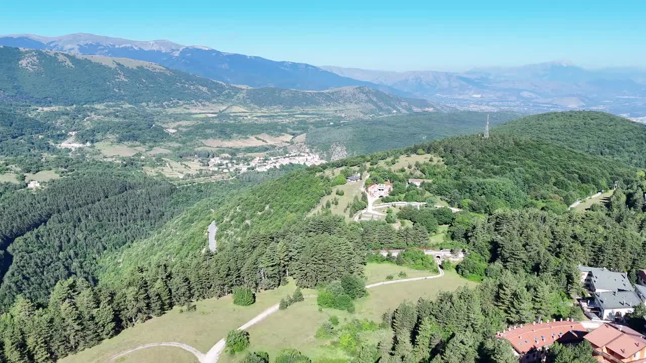 蔚蓝天空下，郁郁葱葱的青山环绕着古雅的村庄，令人叹为观止的鸟瞰图视频下载