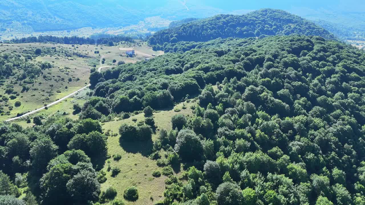 郁郁葱葱的青山俯瞰山谷在一个宁静的乡村景观在明亮的夏日视频素材