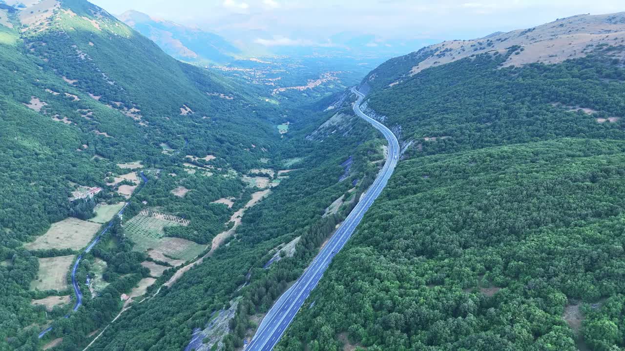 卡车沿着郁郁葱葱的绿色森林环绕的宁静高速公路行驶视频下载