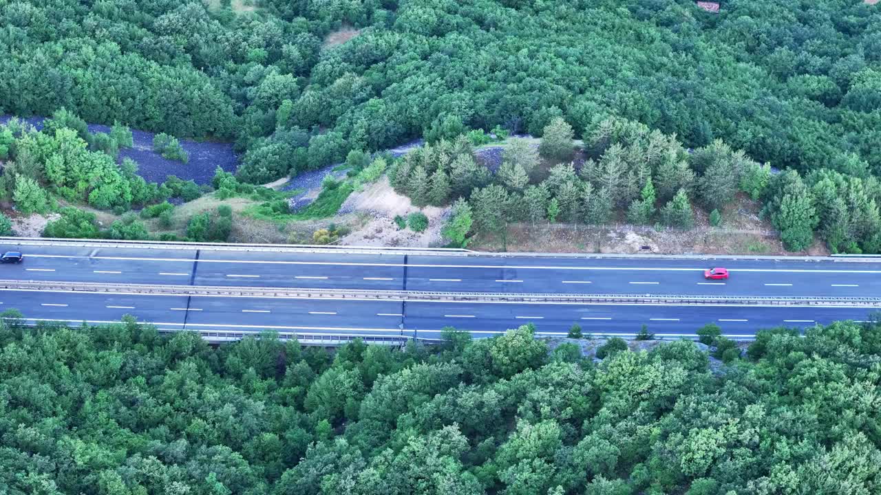 卡车沿着郁郁葱葱的绿色森林环绕的宁静高速公路行驶视频素材