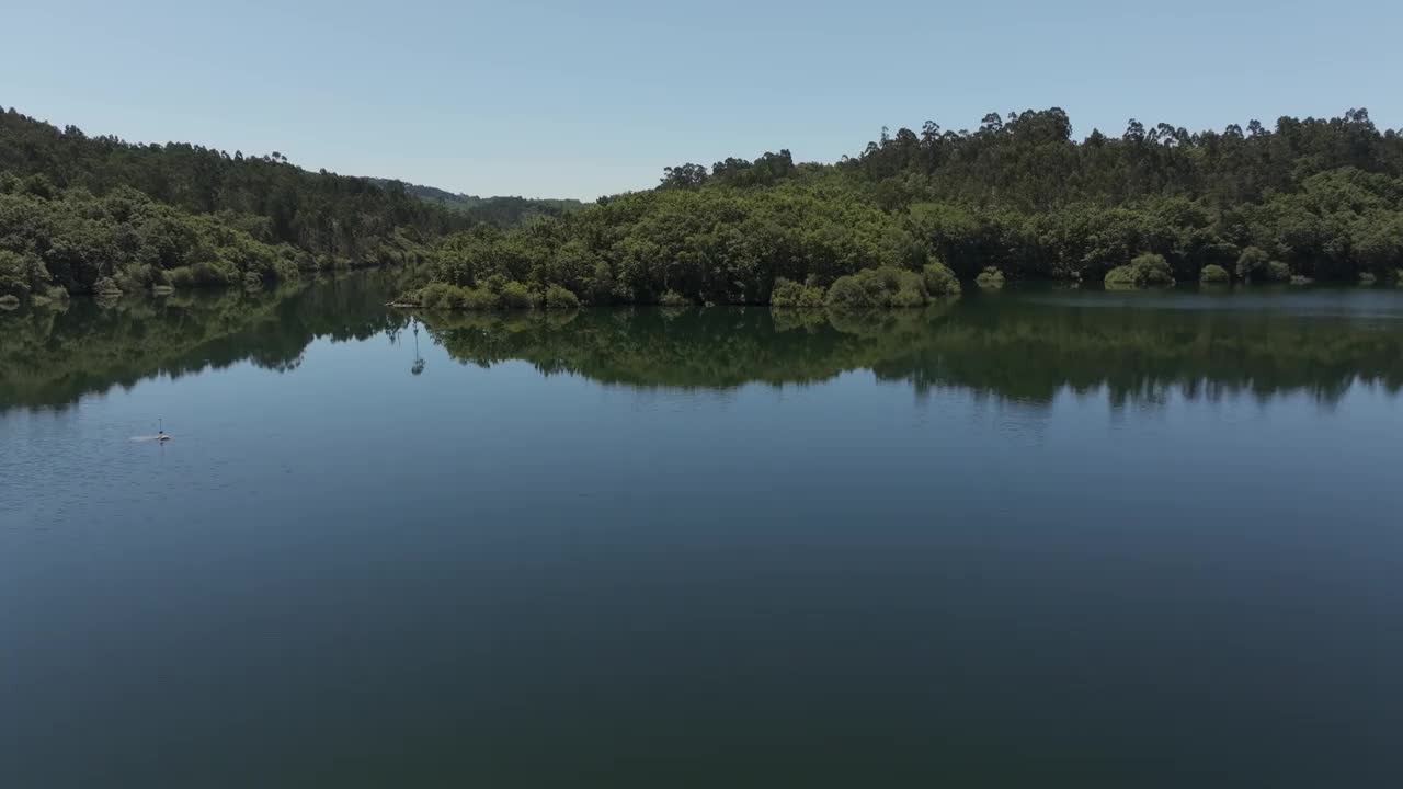 茂密的森林映在宁静的河水上。空中拍摄视频下载