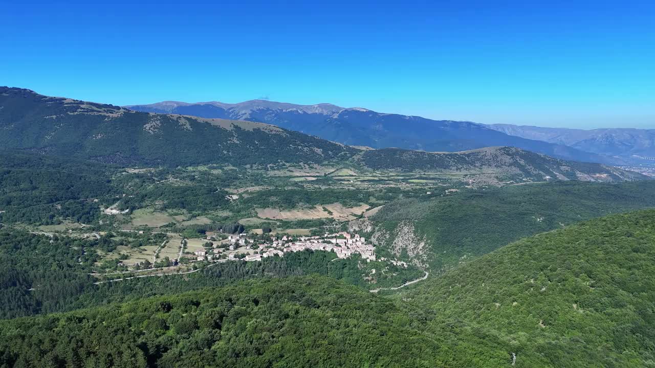 蔚蓝的天空下，郁郁葱葱的绿色山谷环绕着古雅的山村，令人叹为观止视频素材