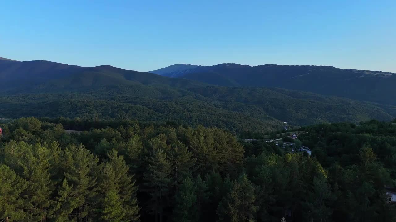 雄伟的山脉俯瞰郁郁葱葱的绿色山谷在黄金时间视频下载