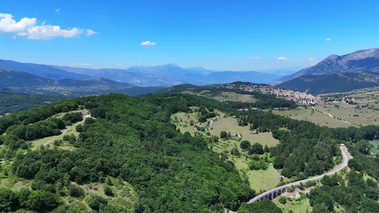 湛蓝天空下广阔的青翠风景和蜿蜒的道路视频素材