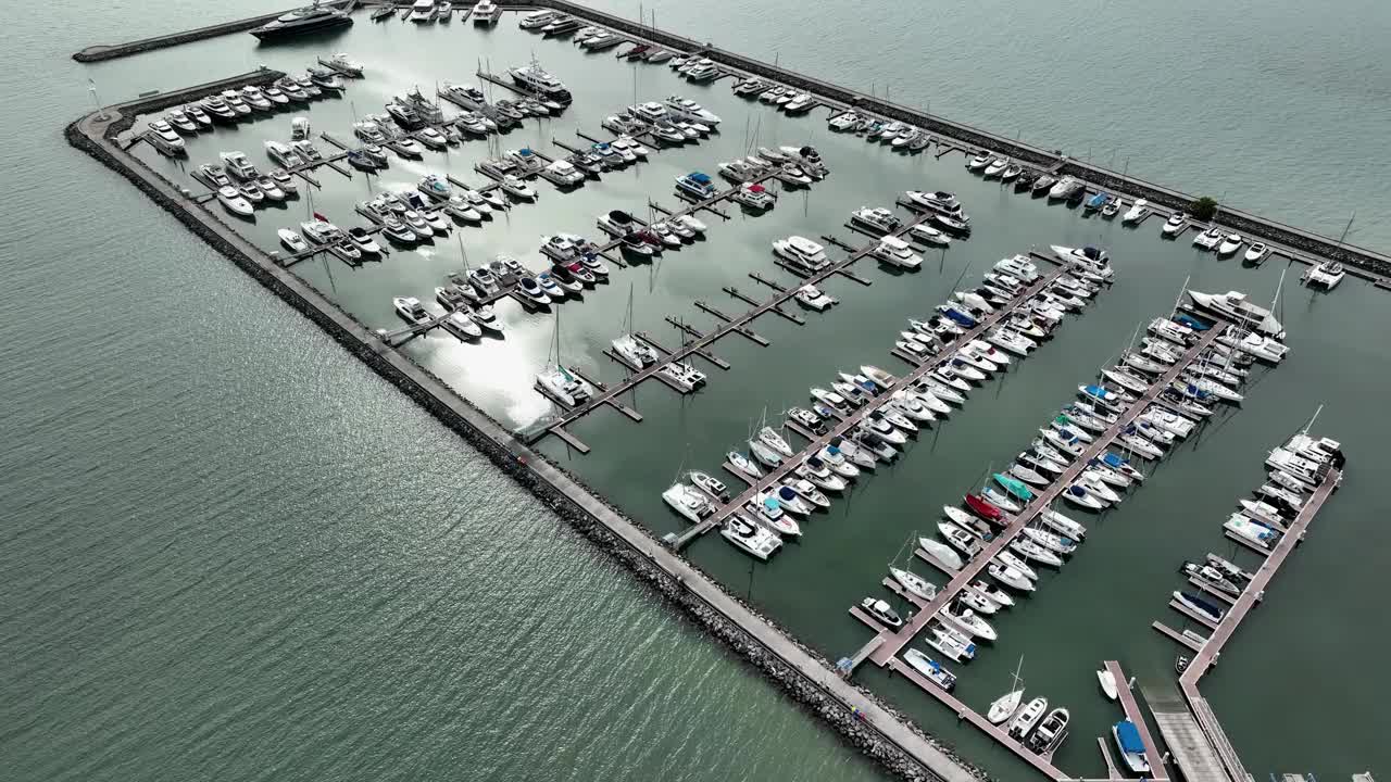 海上，港口，船只和城市建筑的空中无人机视图。度假小镇的壮丽景色，乘坐不同大小的游艇飞越滨海湾视频下载