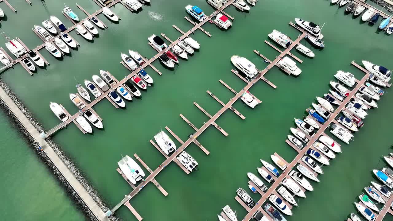 海上，港口，船只和城市建筑的空中无人机视图。度假小镇的壮丽景色，乘坐不同大小的游艇飞越滨海湾视频素材