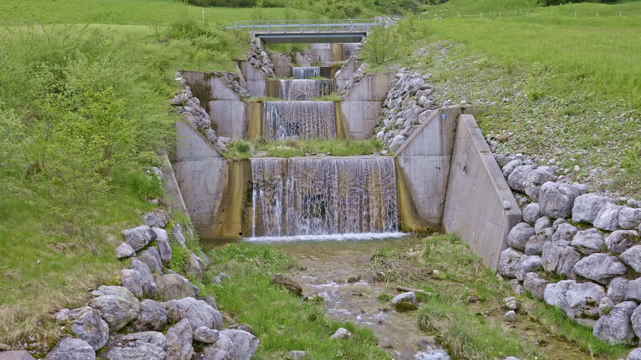 水从人造瀑布倾泻而下。河水绕着石头流动。内瓦尔登州贝肯里德附近的Traeschlibach视频素材