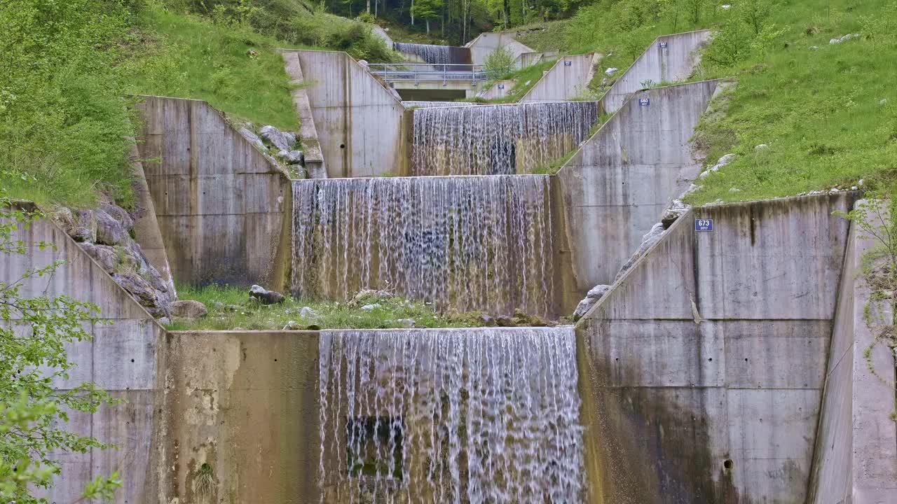 水从人造瀑布倾泻而下。河水绕着石头流动。内瓦尔登州贝肯里德附近的Traeschlibach视频下载