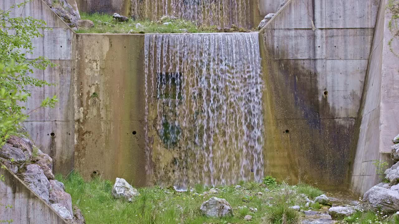 水从人造瀑布倾泻而下，特写。河水绕着石头流动。内瓦尔登州贝肯里德附近的Traeschlibach视频下载