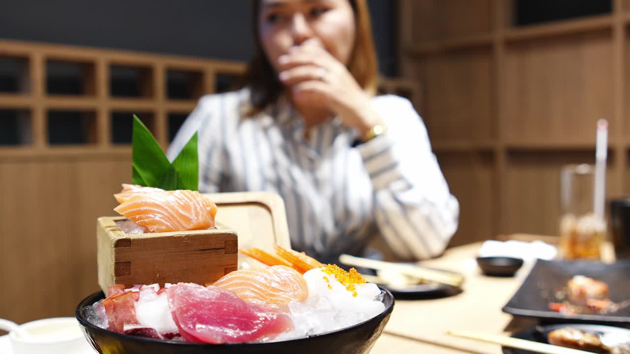 一位亚洲妇女正在一家日本餐厅享用美味的自助餐。视频下载