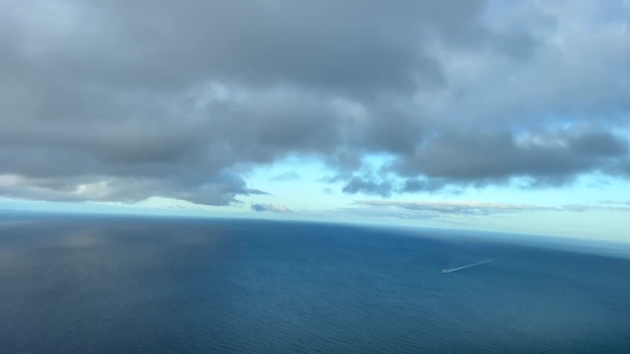 身临其境的飞行员POV飞行下的云和以上的海洋在白天与蓝天。4 k 60 fps视频素材