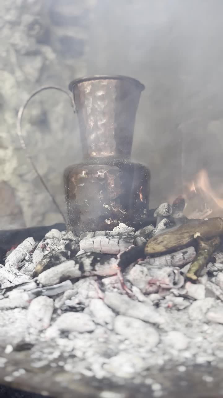 一个古色古香的铜壶矗立在燃烧着的石头壁炉里视频素材