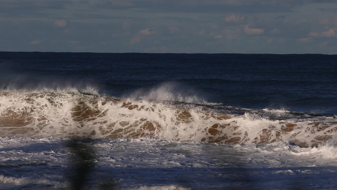 在巨大的风暴中，巨大的海浪沿着海滩撞击。视频素材