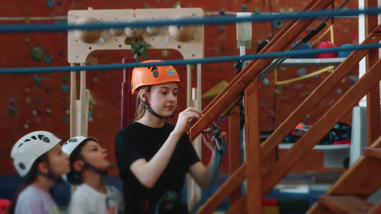 一个穿着防护装备的女孩开始在绳索公园进行障碍训练视频素材