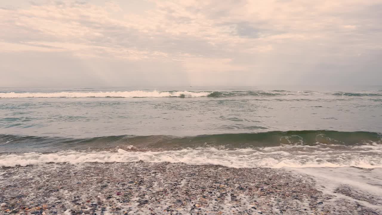 清澈的绿松石海洋海浪冲过海岸与傍晚的阳光效果在地平线的背景。科夫斯港，澳大利亚。副本的空间。视频素材