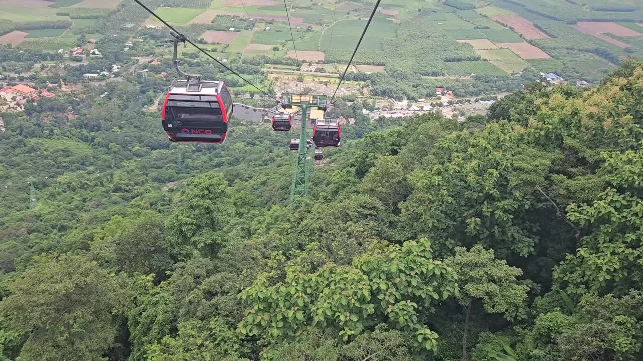 在一个晴朗的日子里，在越南Tay Ninh的巴登山上行驶的缆车。POV森林和绿色背景。视频下载