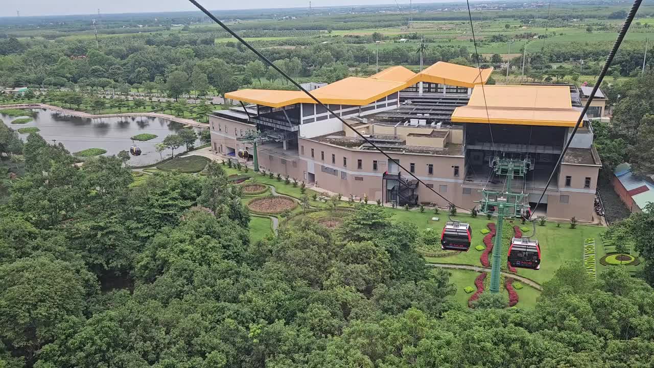 在一个晴朗的日子里，在越南Tay Ninh的巴登山上行驶的缆车。POV森林和绿色背景。视频下载