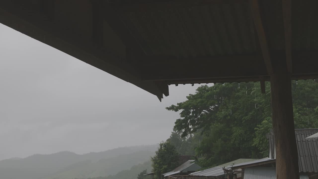 雨水从茅屋的屋檐流下来。在泰国清迈的帕邦屏，细雨蒙蒙的梯田。视频下载