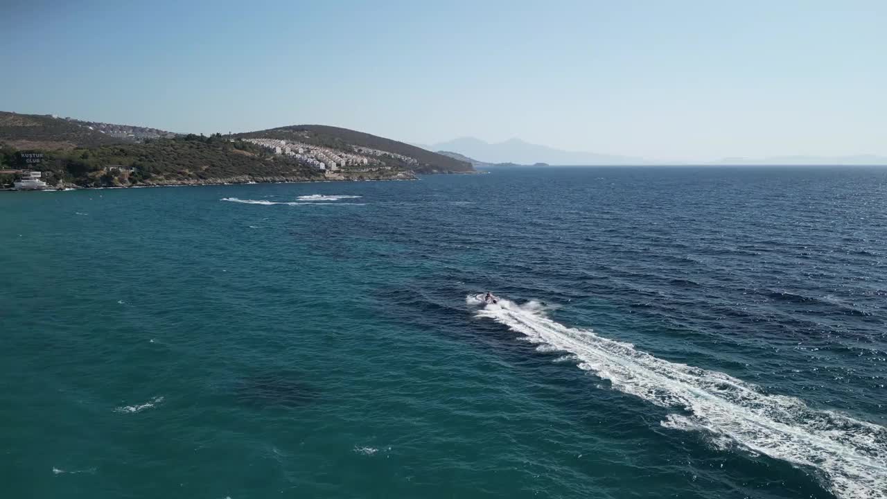 快艇在海上疾速行驶，并在最后的水上运动UHD 4K空中遇到喷气式滑雪视频素材