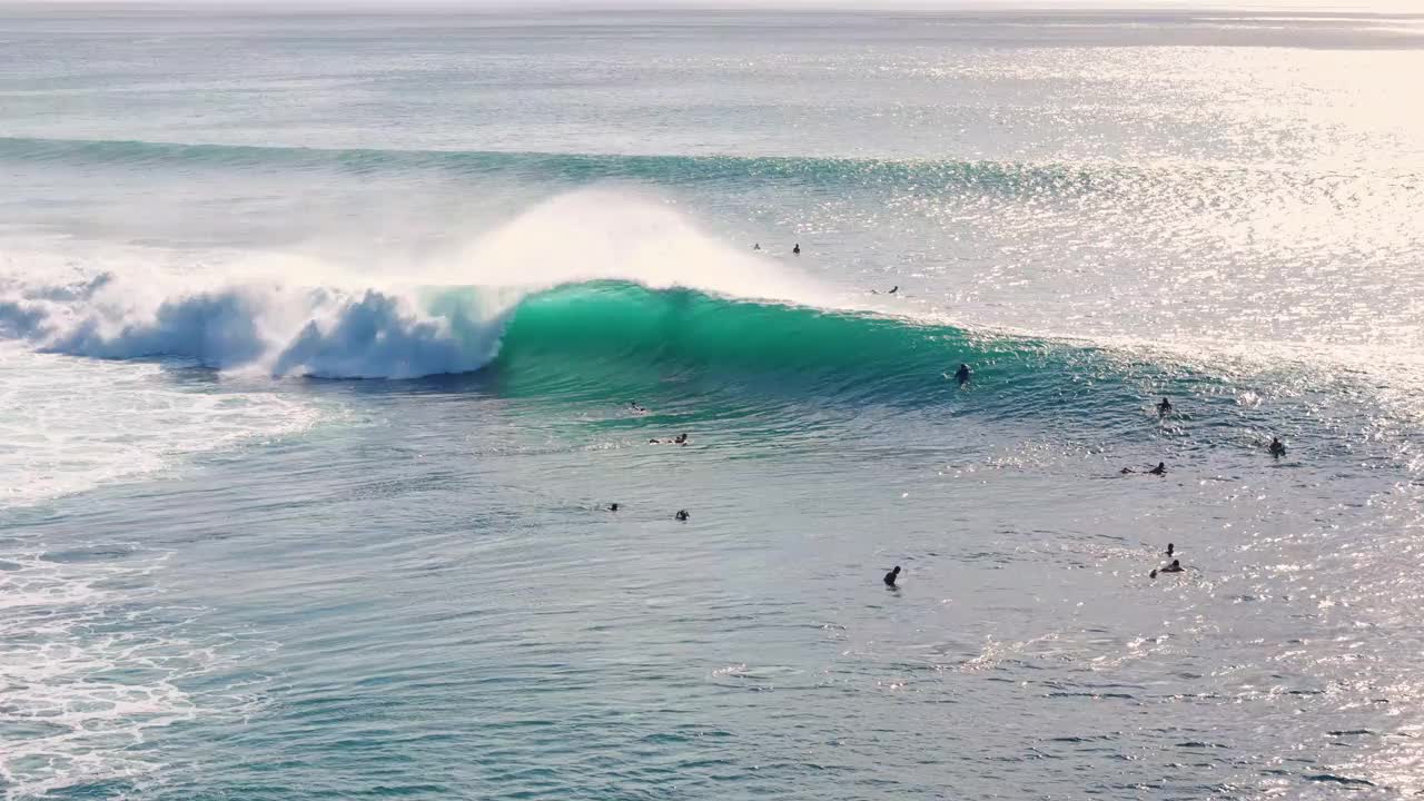 在巴东巴东海滩和冲浪者一起享受完美的海浪。在海浪上冲浪的无人机视图。视频下载