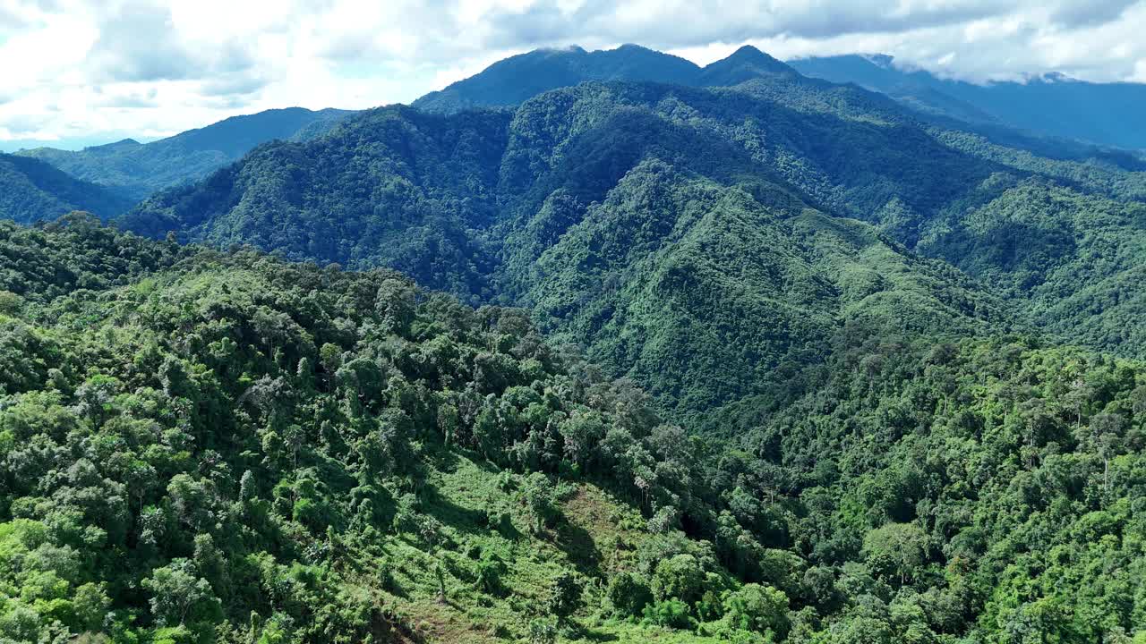 鸟瞰泰国北部雨季期间郁郁葱葱的绿色雨云覆盖的热带雨林山中的森林。视频素材