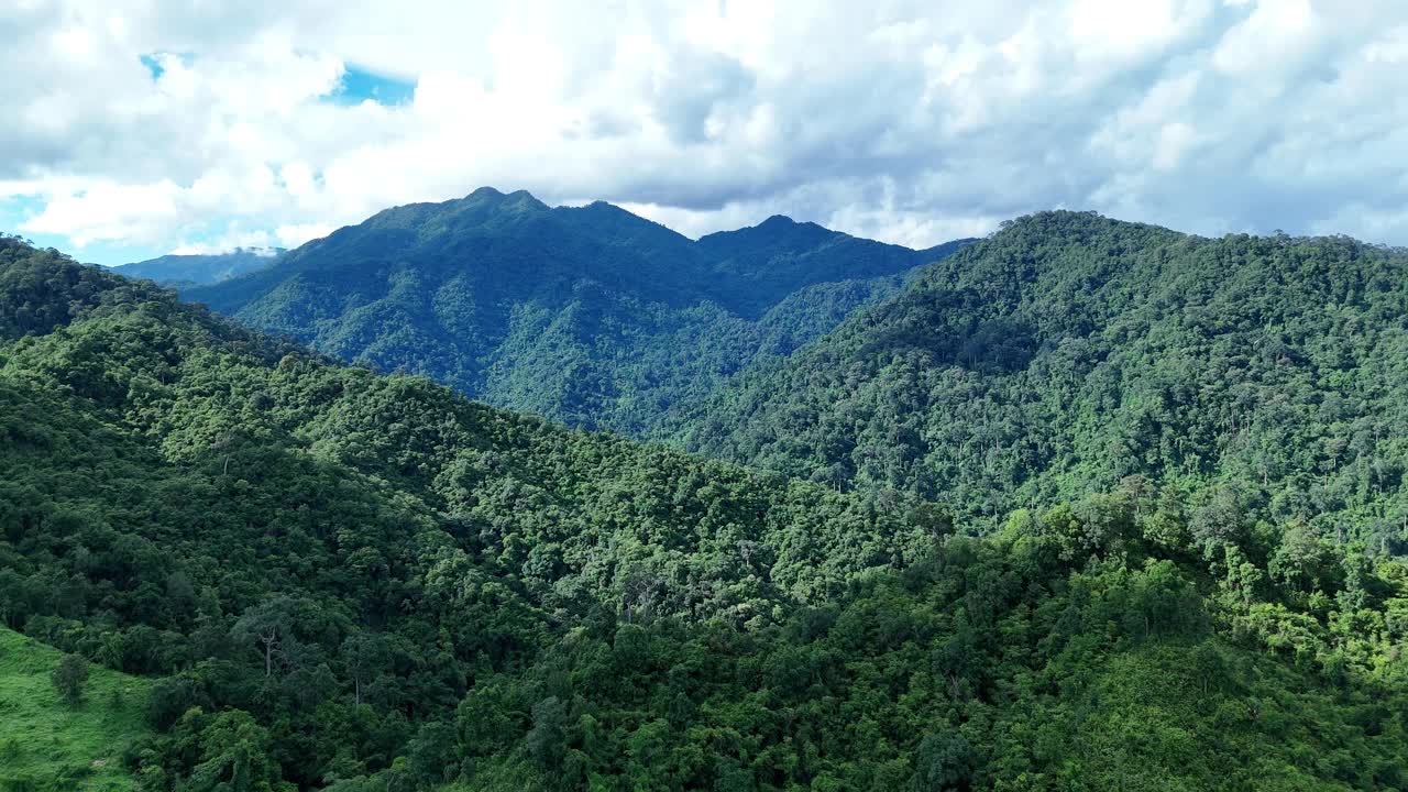 鸟瞰泰国北部雨季期间郁郁葱葱的绿色雨云覆盖的热带雨林山中的森林。视频素材