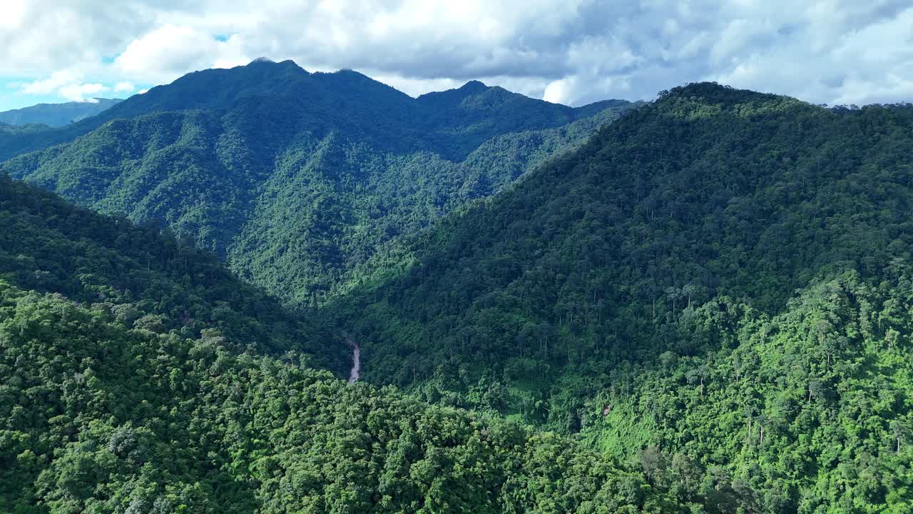 鸟瞰泰国北部雨季期间郁郁葱葱的绿色雨云覆盖的热带雨林山中的森林。视频素材