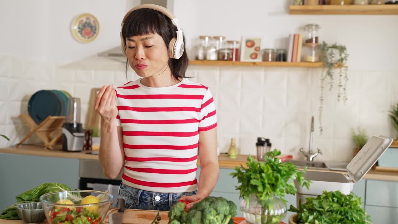 女人一边听音乐一边准备健康的食物视频下载