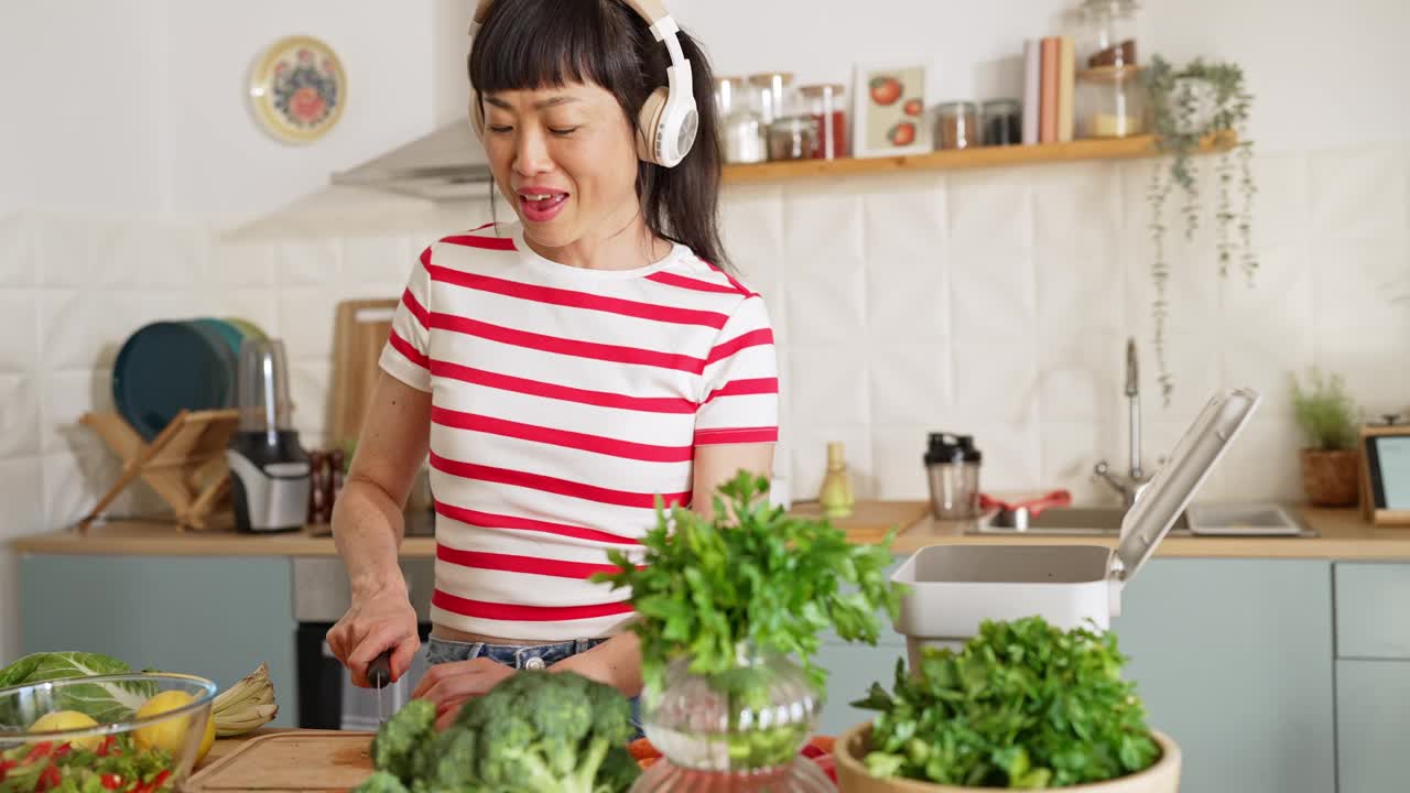 女人一边听音乐一边准备健康食物视频下载