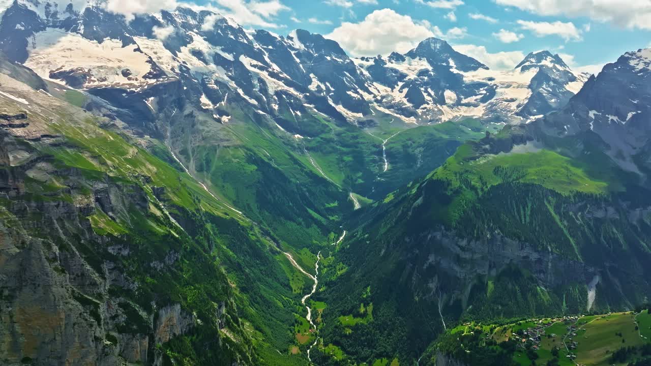 高山间古老的雪冰川。山顶上覆盖着雪。瑞士阿尔卑斯山的多山地形。无人机慢慢飞向山上几乎融化的冰川视频下载