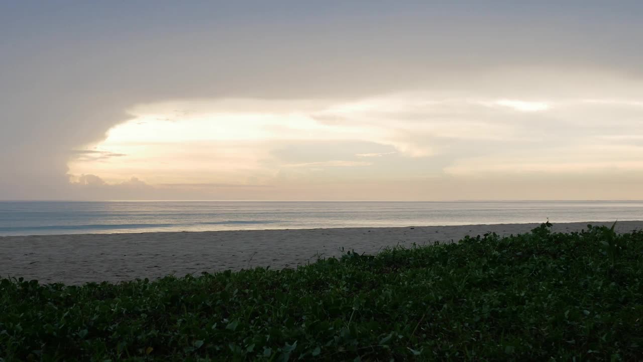 自然景观戏剧性的日落在海面上的海滩表面，在日落的时间与许多云在傍晚的天空。视频下载