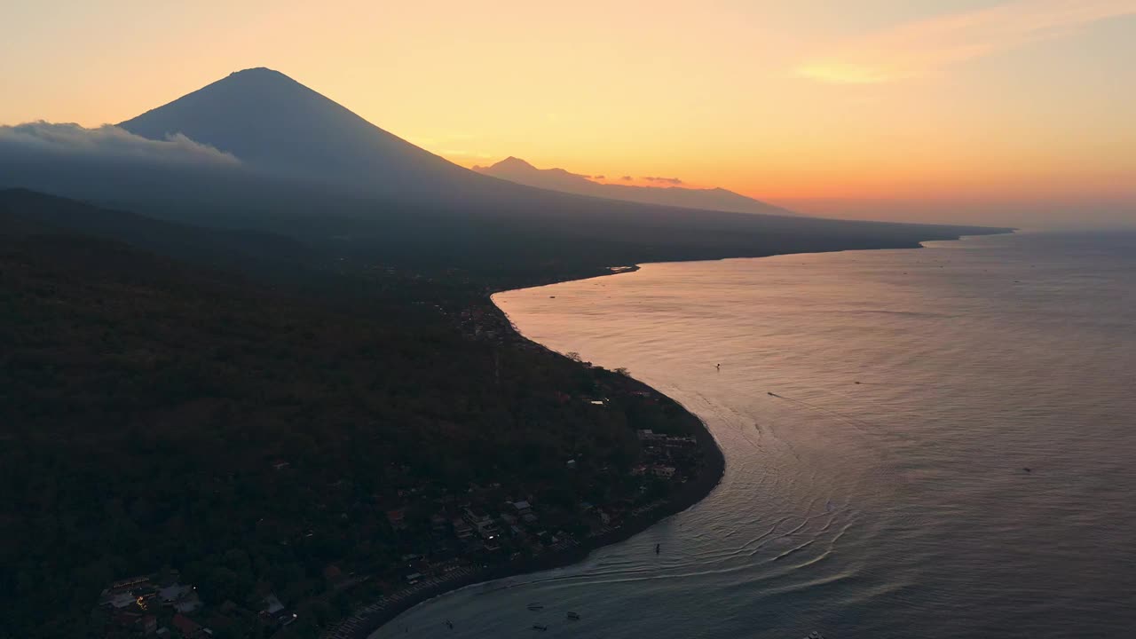 海岸线和火山山在明亮的日落。无人机拍摄的巴厘岛阿米德视频下载