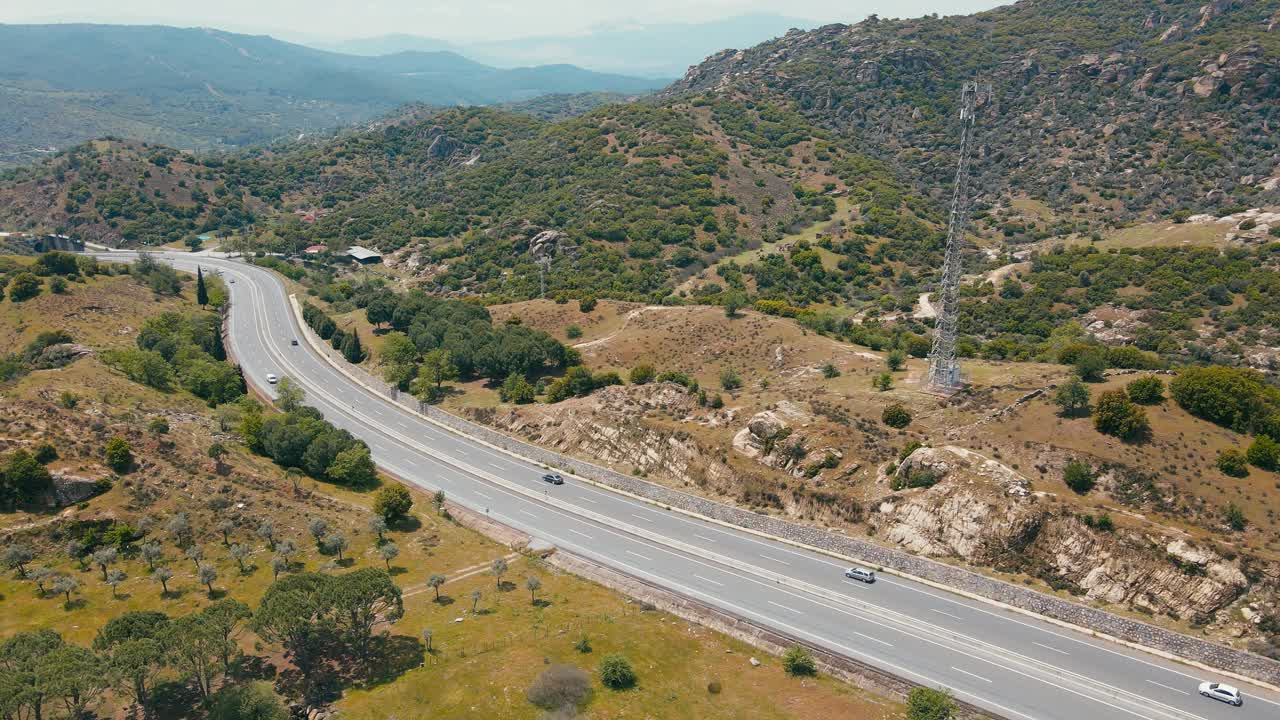 在山路和丘陵之间的高速公路上行驶的车辆视频素材