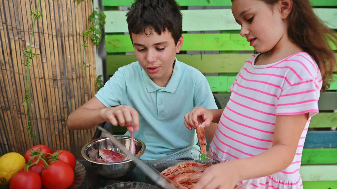 孩子们用新鲜的食材和丰富多彩的环境为家庭户外烧烤准备海鲜视频素材