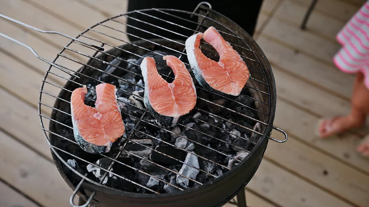 在夏日的户外，用木炭烧烤新鲜的鲑鱼是一顿美味的海鲜大餐视频素材