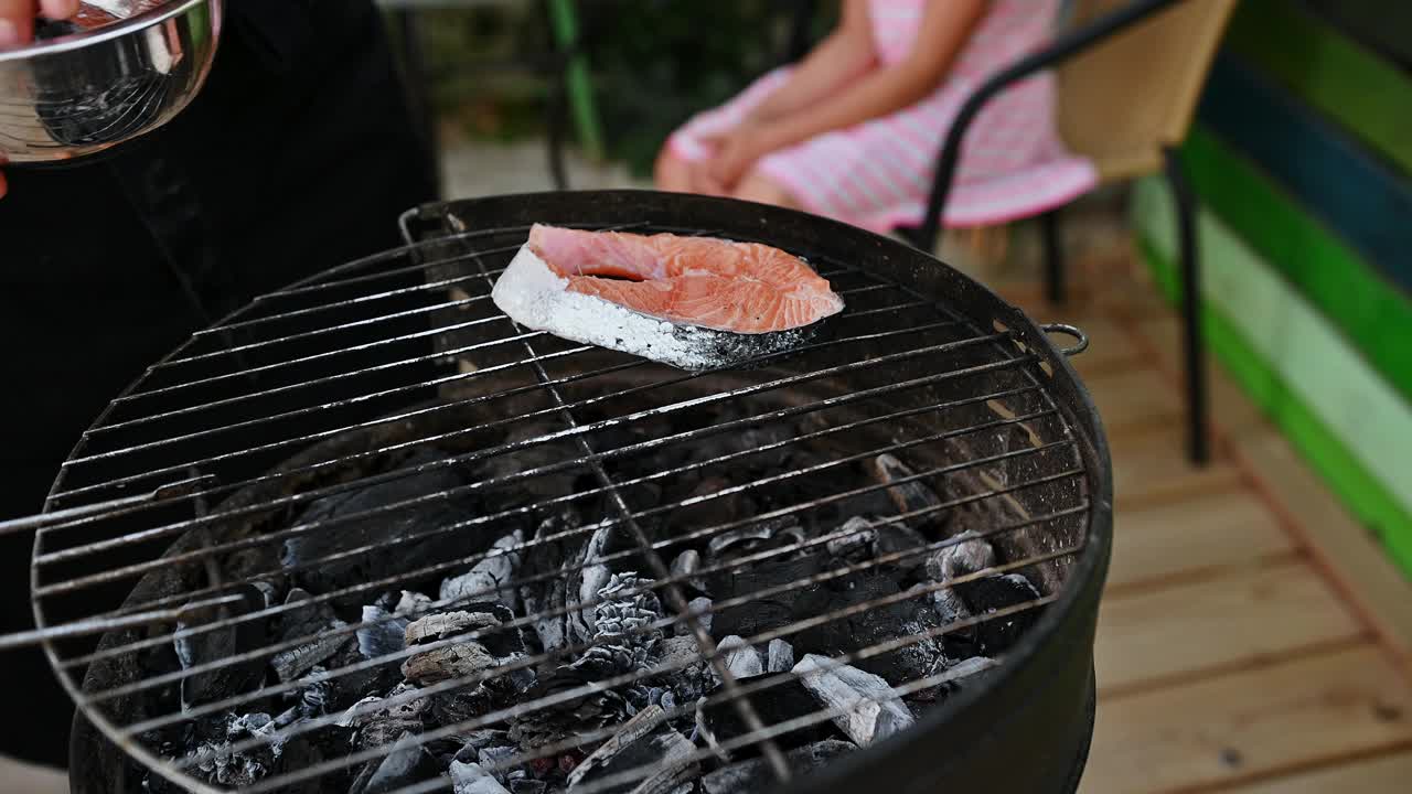 新鲜三文鱼排，炭火烧烤，夏日户外烹饪，家庭氛围轻松视频素材