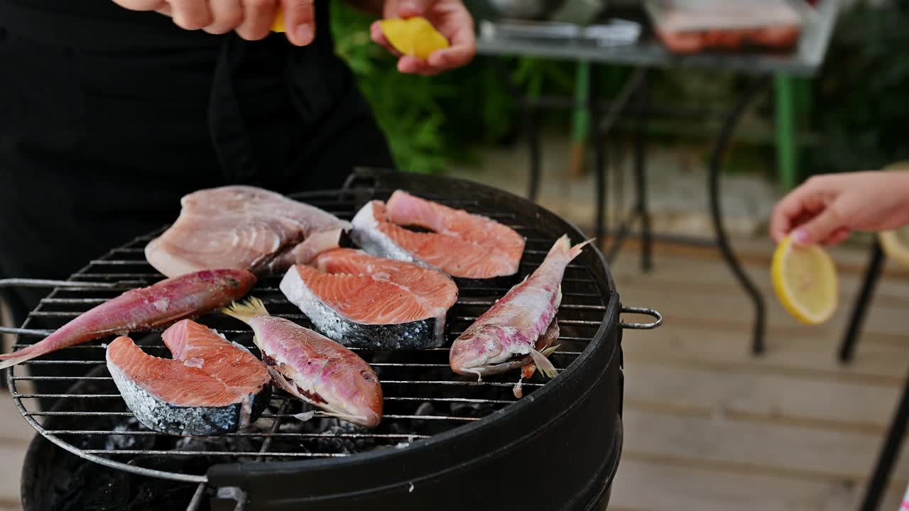 在户外夏季聚会上，双手准备着美味的新鲜海鲜烧烤和柠檬视频素材