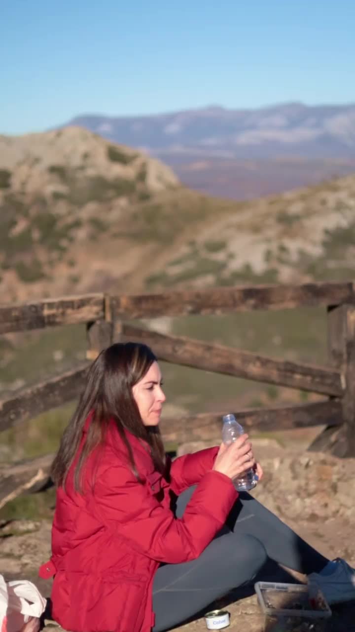 拉丁妇女在大自然中徒步旅行时休息和吃一些食物。视频下载