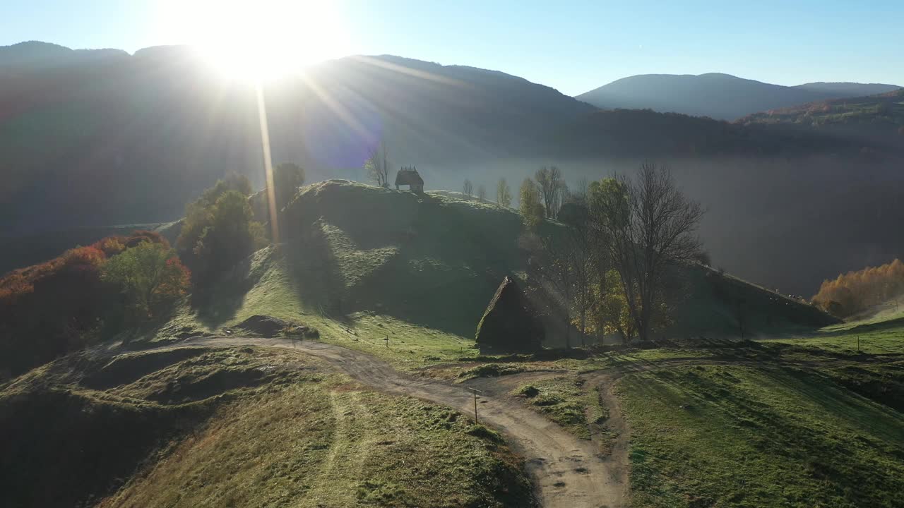 鸟瞰山间牧场，秋天茅草屋顶的木屋视频素材