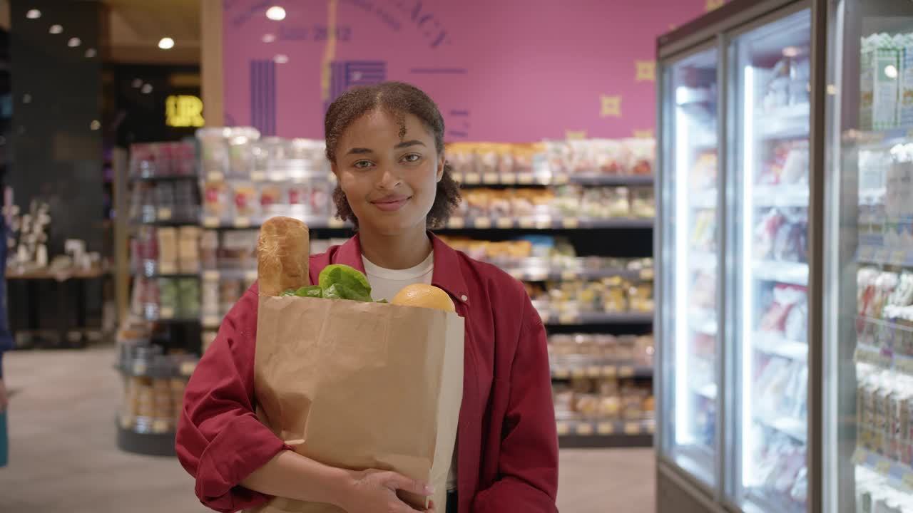 年轻女子在超市拿着袋子买食物视频下载