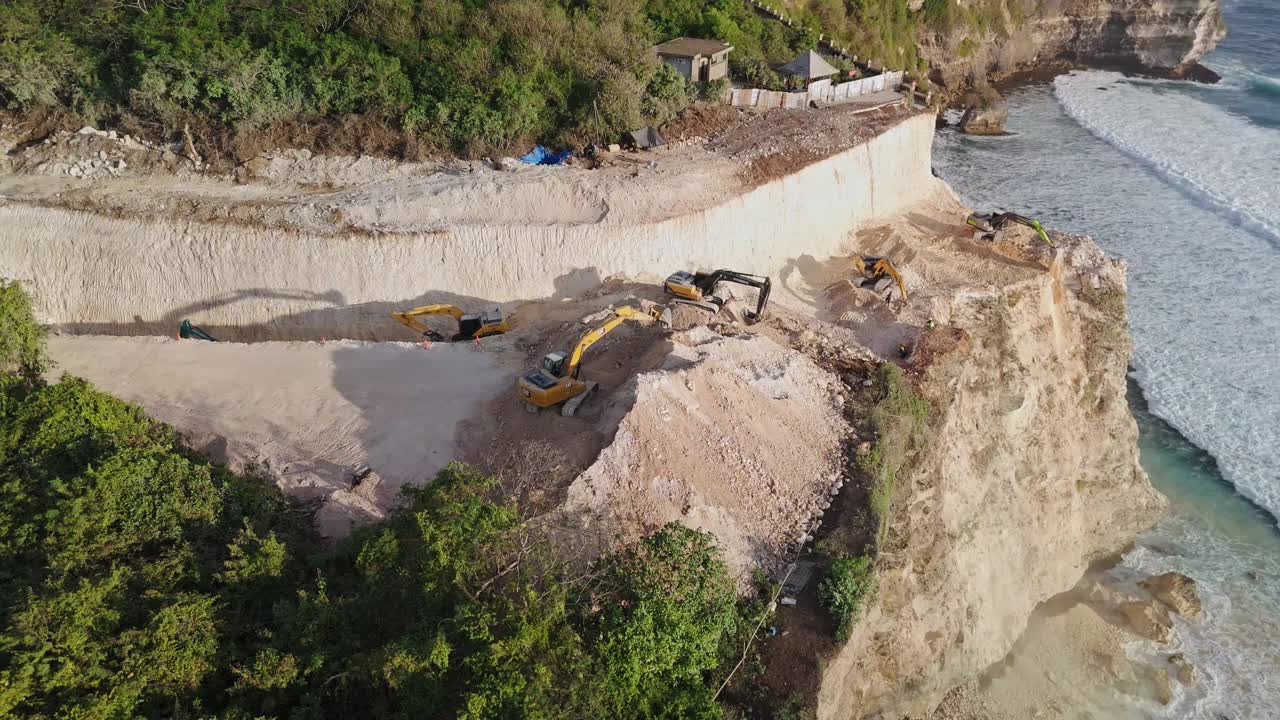 巴厘岛乌鲁瓦图的道路建设。自动扶梯的工作和对岩石的破坏视频下载