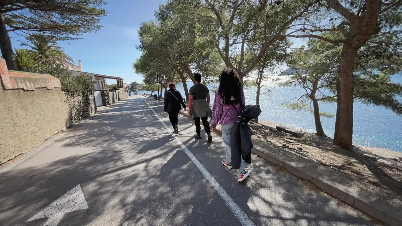 一群人沿着卡达夸斯湾的海岸散步，宁静的景色，西班牙加泰罗尼亚视频下载