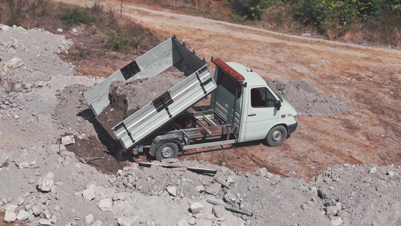 小型自卸卡车从一个新的建筑工地搬运土壤。挖坑视频下载