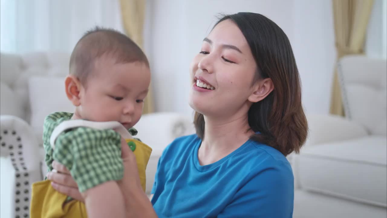 父母和他们的小孩在房子的客厅里快乐地玩耍视频素材