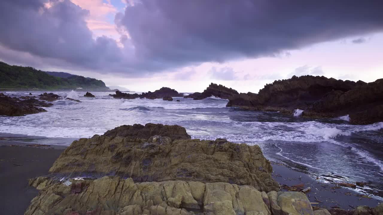 宁静的黄昏潮汐:日落时的岩石湾。苏澳、台湾。视频下载