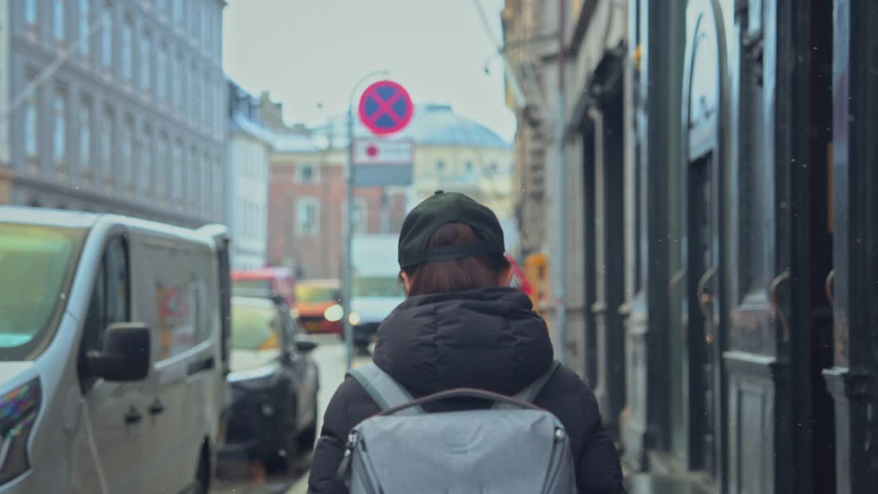 一名穿着冬衣的女游客在下雪的时候漫步在哥本哈根市。丹麦。旅行。视频下载