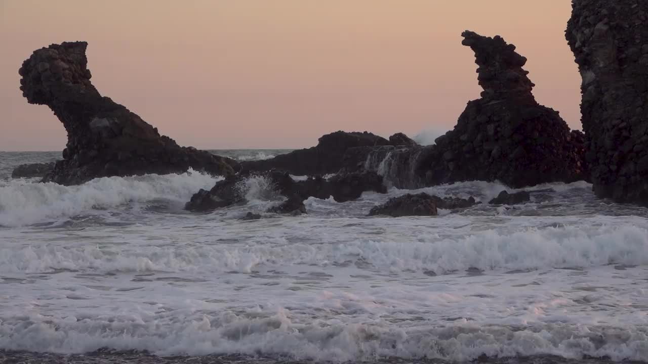 缓慢的海浪冲击着海岸线上的一块大岩石视频素材