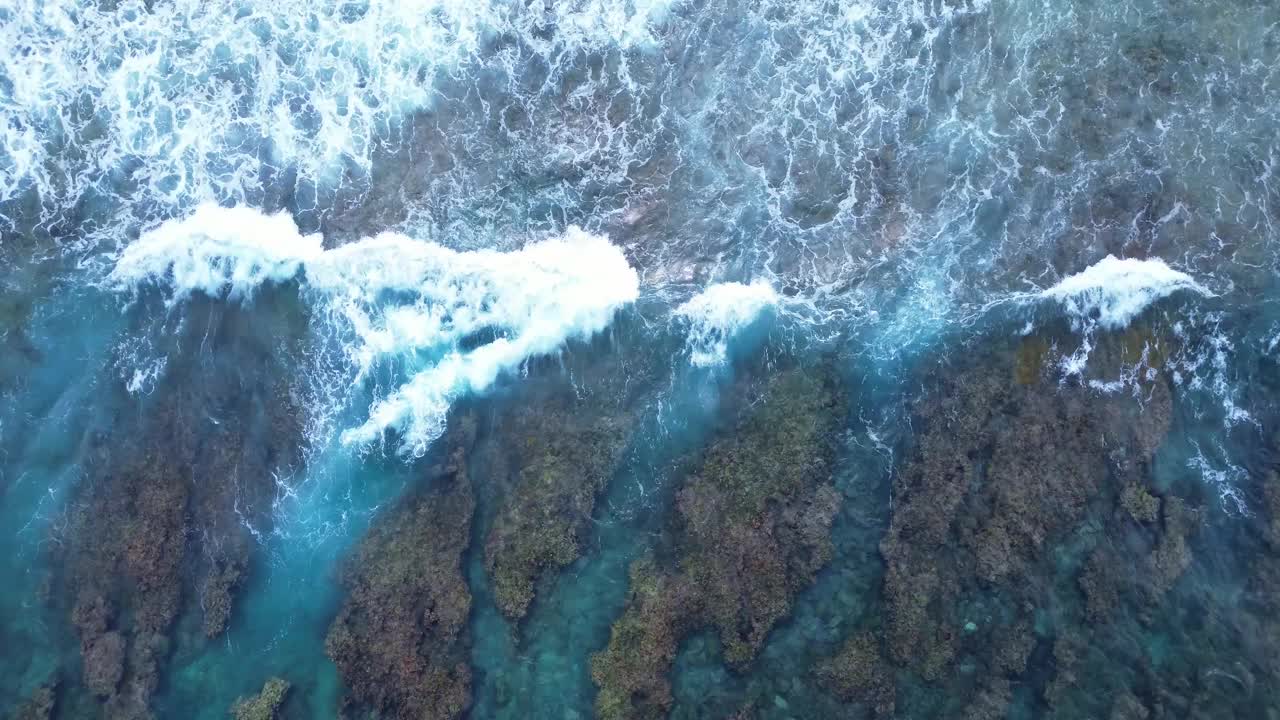 无人机拍摄的马尔代夫海岸珊瑚礁上美丽的海浪。视频素材